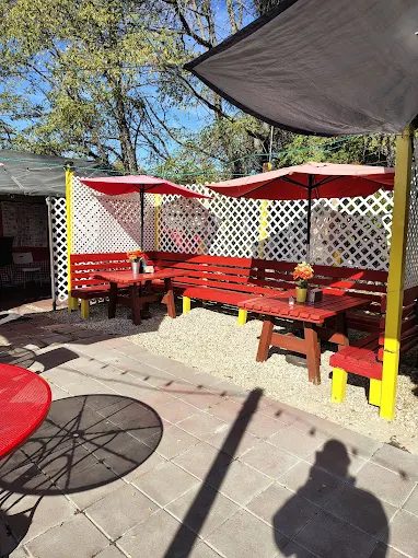 Lorena's outdoor patio with red picnic benches and umbrellas
